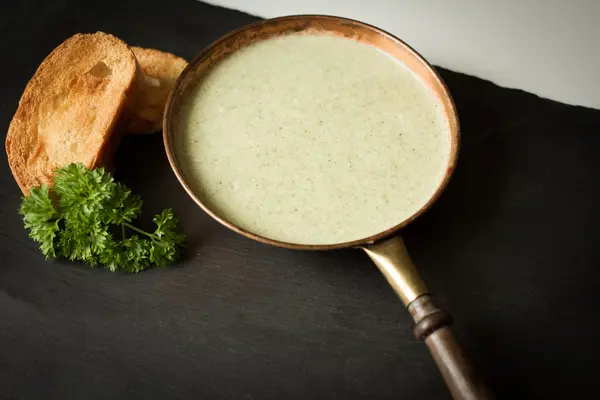 Broccoli soup with toasted bread on a black background — Stock Photo, Image