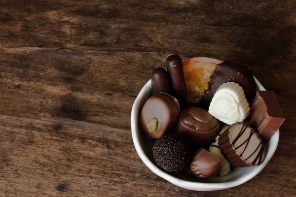 Belgische chocolade in een witte kom op een houten tafel — Stockfoto