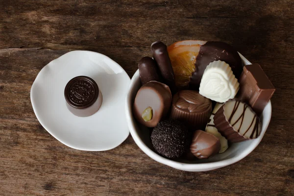 Belgische chocolade in een witte kom op een houten tafel — Stockfoto