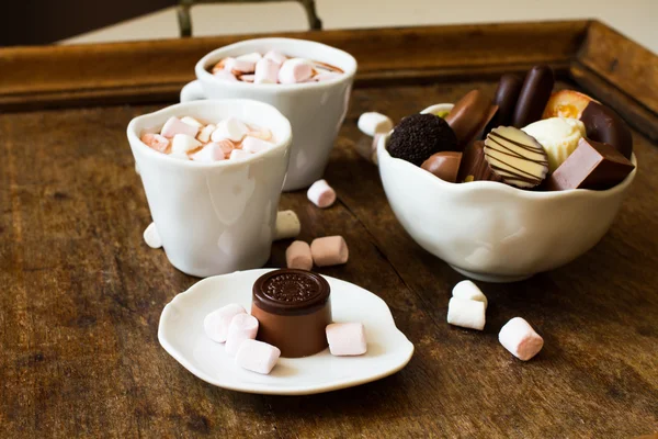 Belgian chocolate in a white bowl on a wooden table — Stock Photo, Image