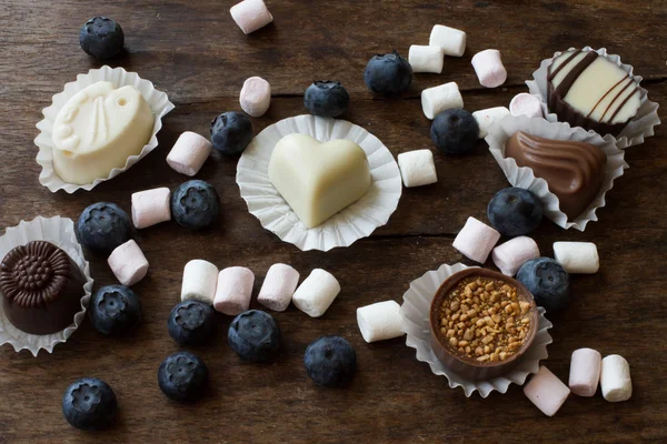 Belgische chocolade en marshmallow op een houten tafel — Stockfoto