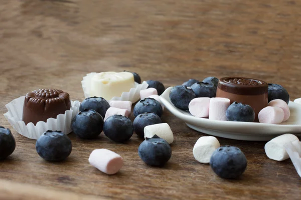 Belgische chocolade en marshmallow op een houten tafel — Stockfoto