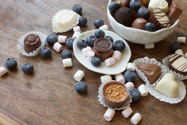 Belgische chocolade en marshmallow op een houten tafel — Stockfoto