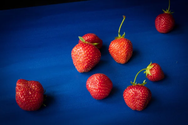 Maturare fragole rosse su sfondo blu — Foto Stock