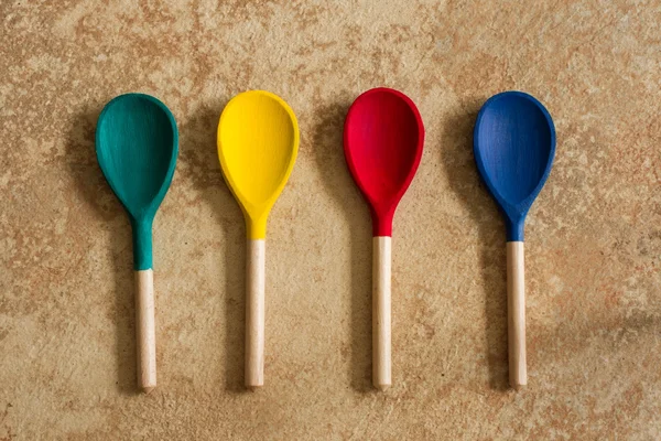 Red yellow blue and green wooden spoons — Stock Photo, Image