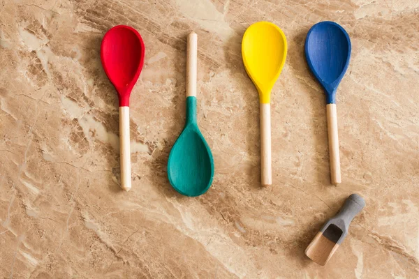 Red yellow blue and green wooden spoons — Stock Photo, Image
