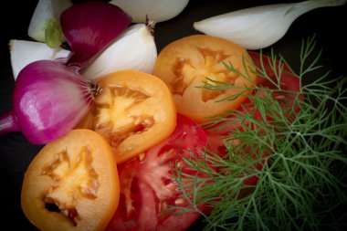 chopped tomatoes with onion and dill on a black stone