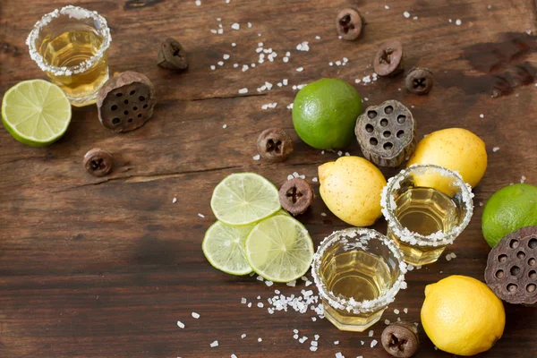 Calce di tequila e limone su un tavolo di legno — Foto Stock