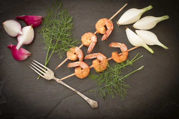 Grilled shrimp with dill on a black stone — Stock Photo, Image