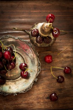 sweet cherry with a metal pitcher and dish in oriental style 