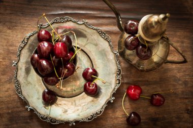 sweet cherry with a metal pitcher and dish in oriental style 