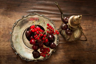 sweet cherry with a metal pitcher and dish in oriental style 