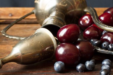 kiraz kırmızı kuş üzümü ve yaban mersini bir sürahi ve metal pl