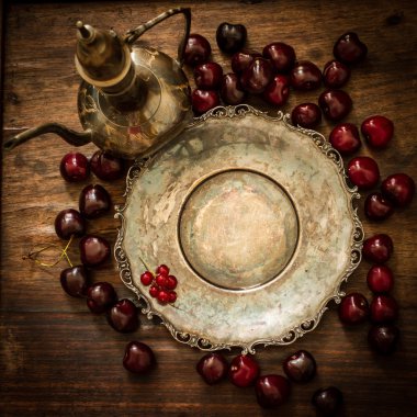 kiraz kırmızı kuş üzümü ve yaban mersini bir sürahi ve metal pl