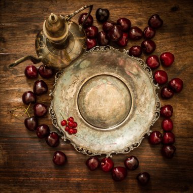 kiraz kırmızı kuş üzümü ve yaban mersini bir sürahi ve metal pl