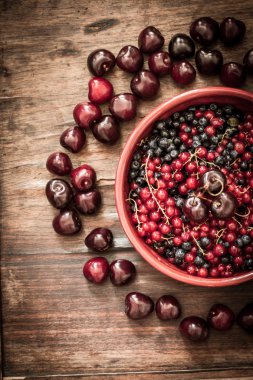 cherry with red currants and blueberries in a red plate