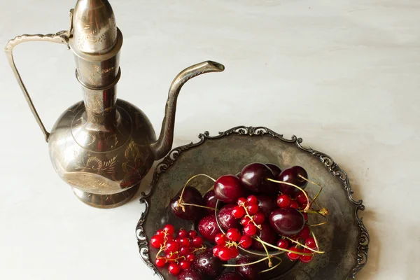 Cereza con grosellas rojas en un bol y una placa de metal en oriental —  Fotos de Stock