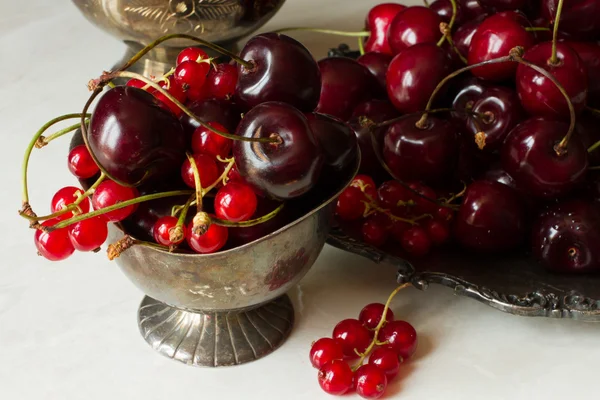 Cherry with red currants in a bowl and a metal plate in oriental — Stock fotografie