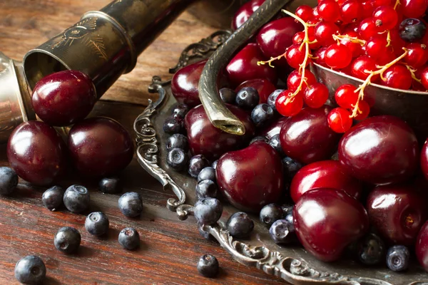 樱桃与红色醋栗和蓝莓在一个水罐和金属 pl — 图库照片