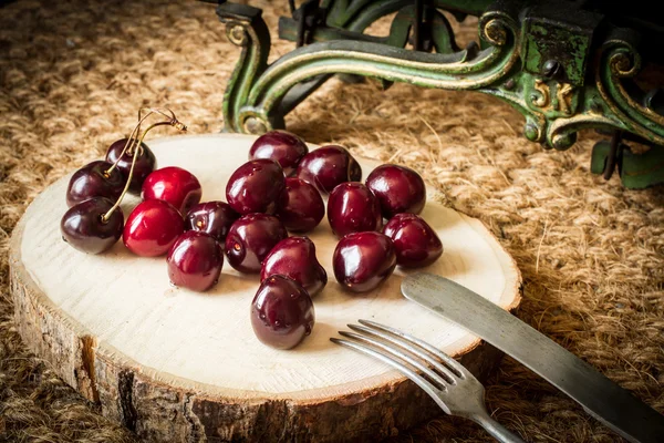 Cerezas con escamas de cocina verde y madera cortada —  Fotos de Stock