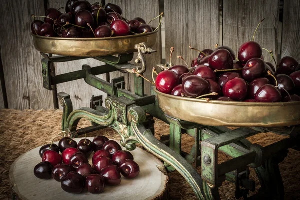 Cerezas con escamas de cocina verde y madera cortada —  Fotos de Stock