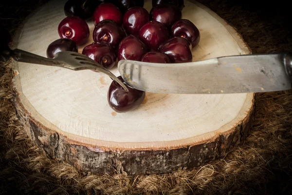 Cereza en un árbol cortado con cuchillo viejo y tenedor —  Fotos de Stock