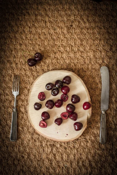 Cereza en un árbol cortado con cuchillo viejo y tenedor —  Fotos de Stock