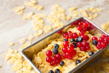 corn flakes with red currants and blueberries for breakfast