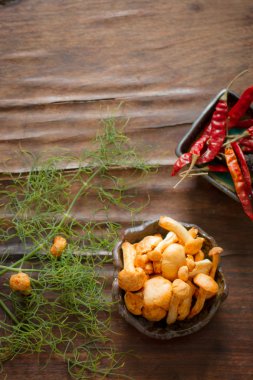 chanterelles chili biber ve ahşap bir masa üzerine dereotu ile