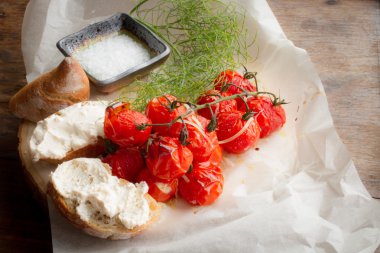 pişmiş domates ekmek ve ahşap bir masa üzerine dereotu