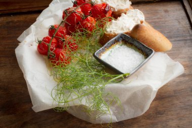 pişmiş domates ekmek ve ahşap bir masa üzerine dereotu