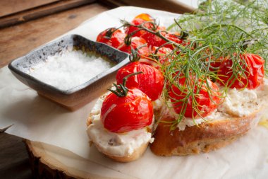 pişmiş domates ekmek ve ahşap bir masa üzerine dereotu