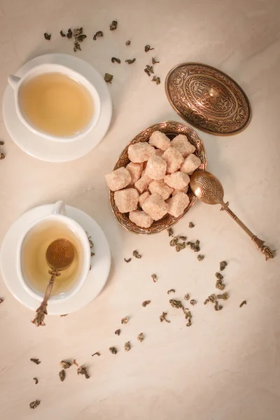 Grönt te i orientalisk stil med brunt socker på en vit marmor — Stockfoto
