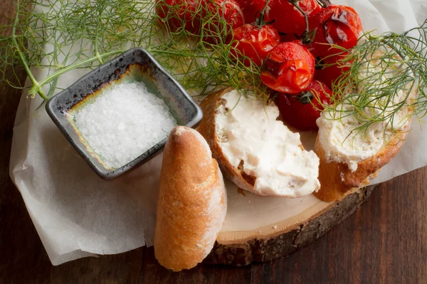 pişmiş domates ekmek ve ahşap bir masa üzerine dereotu