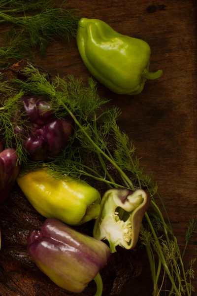 Pepe viola e verde con aneto su fondo di legno — Foto Stock