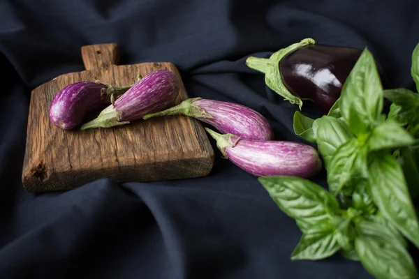 Piccola melanzana con basilico su fondo nero — Foto Stock