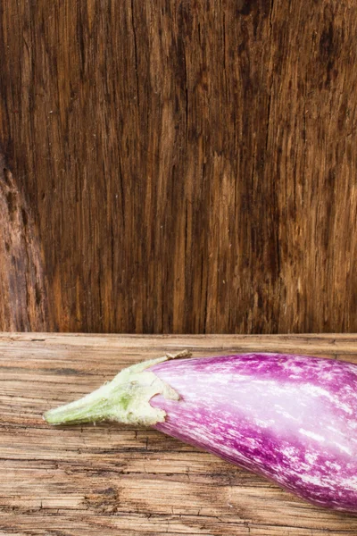 Berenjena pequeña en una tabla de cortar de madera —  Fotos de Stock