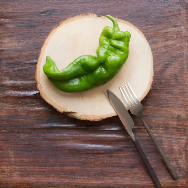 Poivre vert sur une vieille planche à découper en bois sur un fond en bois — Photo