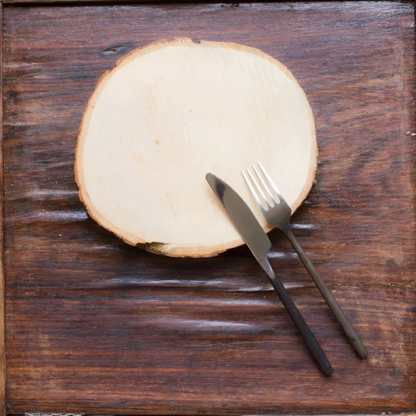 Vieja tabla de cortar de madera sobre un fondo de madera — Foto de Stock