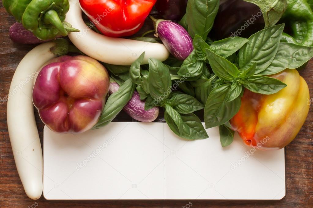 green pepper and basil and eggplant on a wooden cutting board an