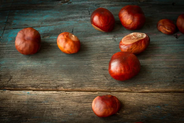 Castanhas maduras em um fundo de madeira — Fotografia de Stock