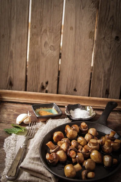Champiñones fritos con sal y pimienta sobre fondo de madera —  Fotos de Stock