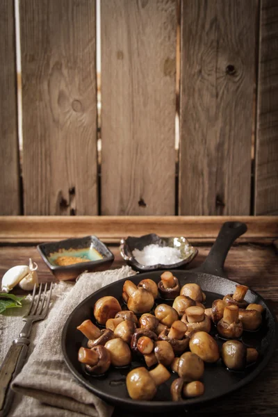 Champiñones fritos con sal y pimienta sobre fondo de madera —  Fotos de Stock