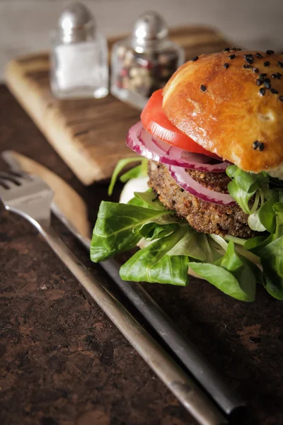 homemade veggie burger in a bun with sesame seeds of beer. delic