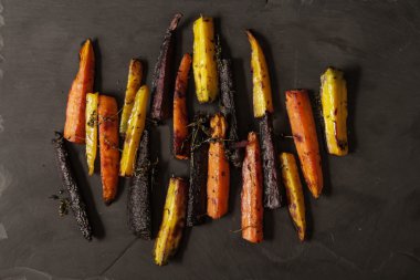 siyah bir arka plan üzerinde renkli havuç pişmiş