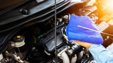 Mühendisler arabaları kontrol ediyor. Gün batımında ışık altındır. Motorları kontrol eden genç çalışanların bulanık görüntüsü. Araçların kalite denetimi konsepti Motor bakımı her zaman.