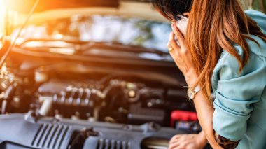 İş kadınlarının yol kenarında araba sorunları olur. Gün batımında ışık altındır. Genç kadınlar araba tamircisini arıyor. Araçların kalite denetimi konsepti Motor bakımı her zaman.