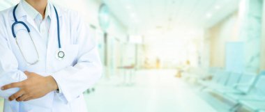 Elinde üniformalı bir steteskop olan bir tıp doktoru. Hastanenin geçmişi bulanık. Sabahın altın ışığı camdan süzüldü, sıcacık görünüyordu..