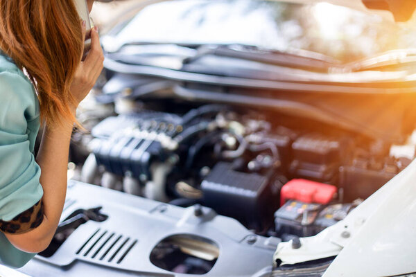 У деловых женщин проблемы с машиной на обочине дороги. Молодые женщины вызывают автомеханика. Концепция контроля качества автомобилей Обслуживание двигателей постоянно.