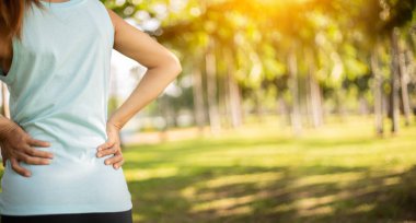 Genç bir kadın sabah uyandığında boynu ağrıyan pijamalarını giyer ve beyaz arka planda tek başına dolaşır..